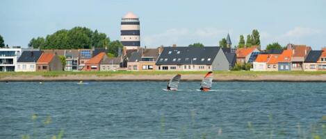 A waterfront view with houses and a tower.