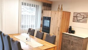 A compact kitchen with wooden cabinets, a built-in oven, and a coffee maker on the countertop. - Ferienhaus Adonis by Interhome (Saas-Grund)