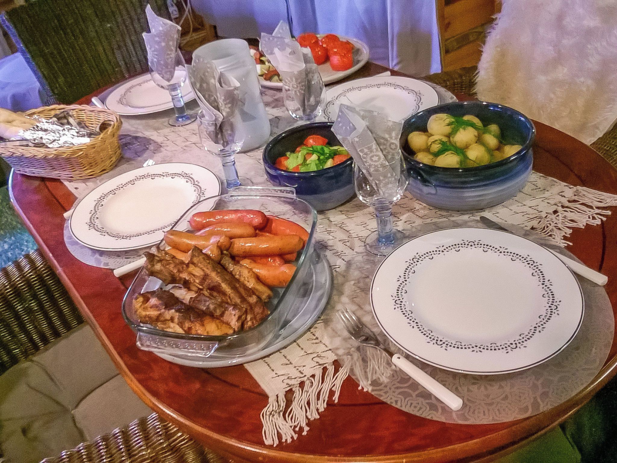 Une table à manger dressée avec des assiettes, des bols et un panier.
