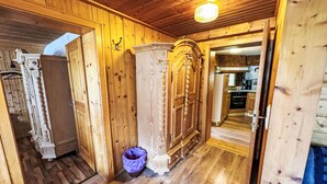 Een houten interieur, met een keuken zichtbaar door een open deur.