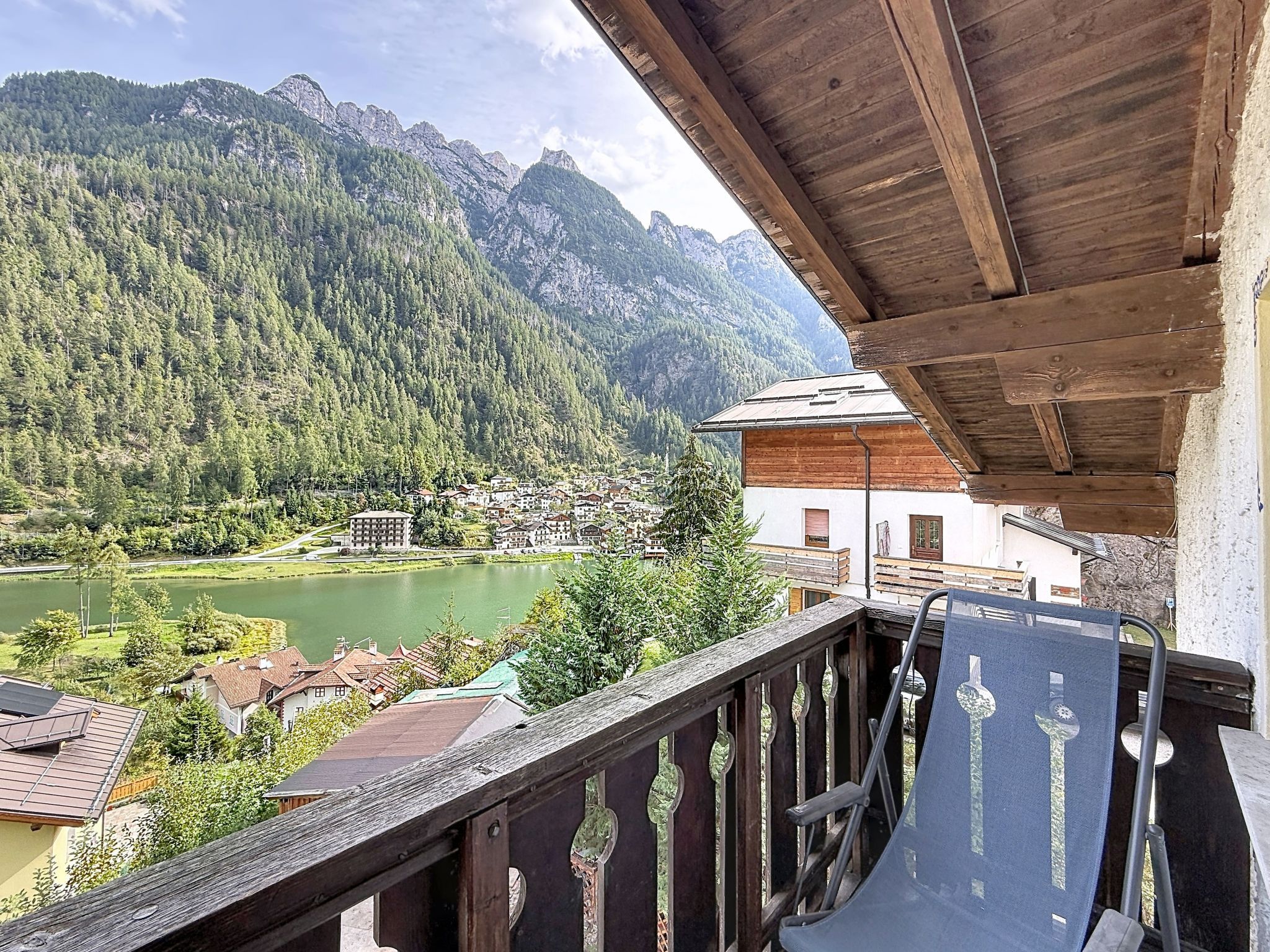 Un balcone con vista su una montagna, un lago e un villaggio.