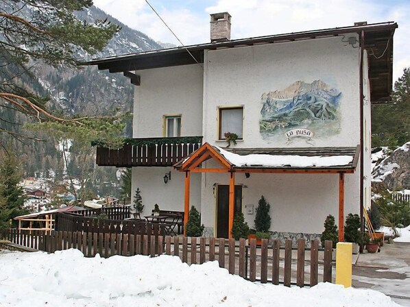 A two-story building with a mountain view, a balcony, and a wooden fence. - La Busa by Interhome (Alleghe)