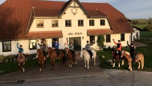 A building with the sign "Alte Schule" and a group of people on horses in front. - Hiddensee by Interhome (Dargun)