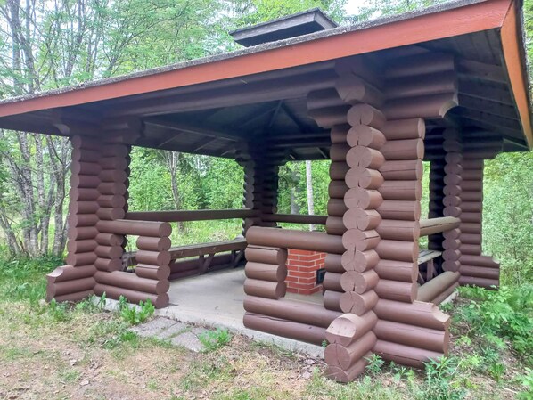 A wooden cabin with a porch and a brick fireplace. - Ranta-koivu by Interhome (Kinnula)