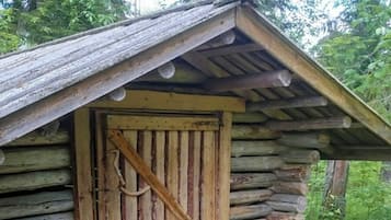 Un rustico chalet di legno con una porta in legno e un portico semplice.