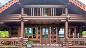 Eine Blockhütte mit Veranda, Holztüren und -fenstern.