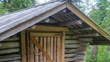 A rustic log cabin with a wooden door and a simple porch.