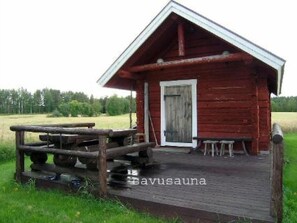 Simple cabin with a cozy porch and a natural setting.