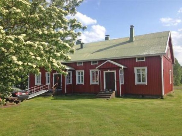 Charming farmhouse with a front porch and lush surroundings.