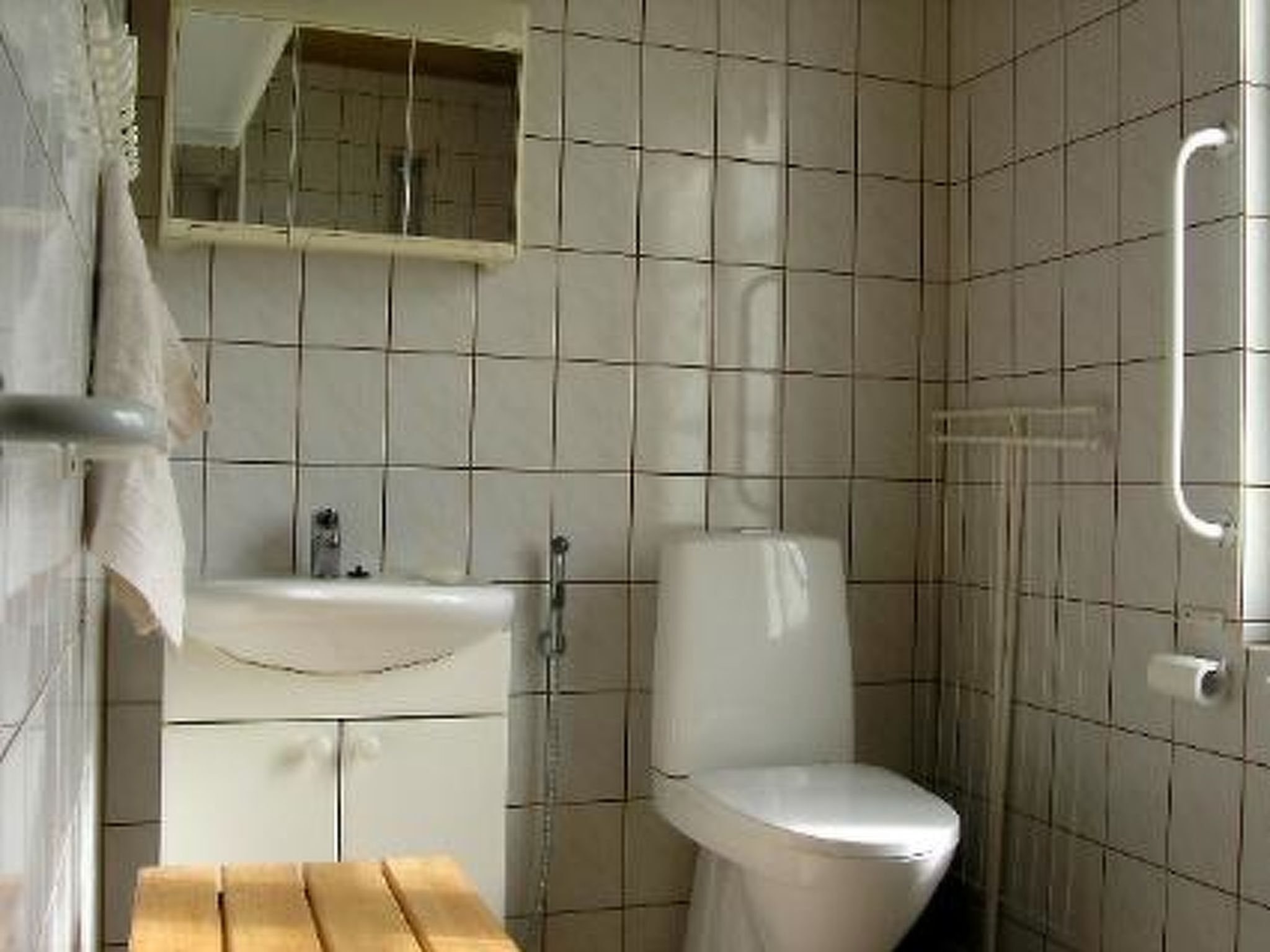 Ein Badezimmer mit Toilette, Waschbecken und Spiegel.