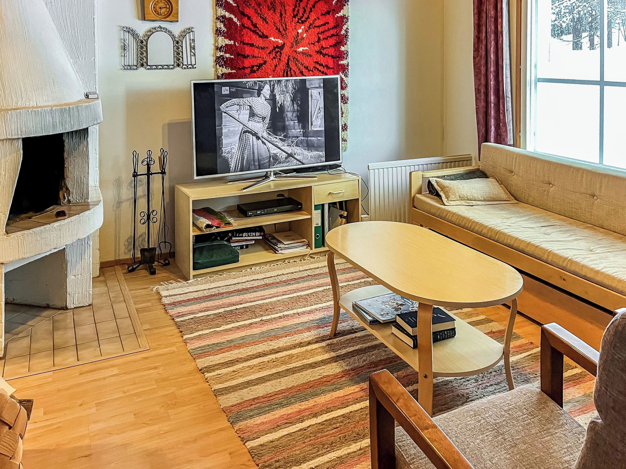 Ein gemütliches Wohnzimmer mit Kamin, Fernseher, Sofa und Couchtisch.
