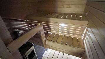 A wooden interior with a sloped ceiling and a metal railing.