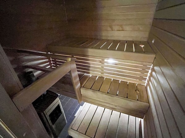 A wooden interior with a sloped ceiling and a metal railing.