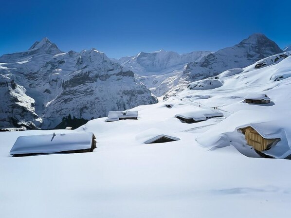 A snow-covered mountain landscape with wooden cabins. - Chalet Schwendihus by Interhome (Grindelwald)