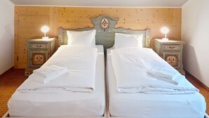 A double bed with white linens, two bedside tables with lamps, and a wooden headboard with decorative carvings. - Chalet Schwendihus by Interhome (Grindelwald)