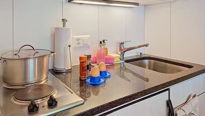 A kitchen with a Bosch stove, a sink, and a countertop with various items. - Chalet Schwendihus by Interhome (Grindelwald)