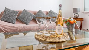 Ein Glastisch mit einer Flasche Grigio de Seigneurs 2020, vier Weingläsern und einer gewebten Tischmatte.