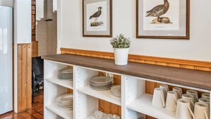 A kitchen with white cabinets, a wooden countertop, and two framed bird illustrations on the wall. - Kivitasku by Interhome (Somero)