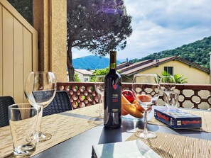 Ein Tisch im Freien mit einer Roséwein-Flasche, Gläsern und einem Gesellschaftsspiel.