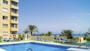 A swimming pool with lounge chairs and a view of the sea. - Puerto Paraíso by Interhome (Estepona)