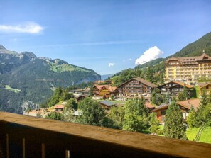 Una località montana con edifici in stile chalet, un grande albergo e vista sulle montagne circostanti.