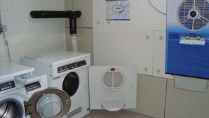 Un cuarto de lavado con lavadora, secadora y sistema de ventilación.
