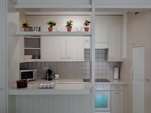 A modern kitchen with white cabinetry, a microwave, a coffee machine, and a dishwashing unit. - Blumenweg 2 Appartement/Fewo 4-Bettwohnung by Interhome (Engelberg)