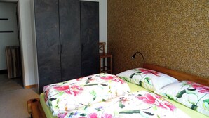Un dormitorio con cama, armario y pared con diseño texturizado.