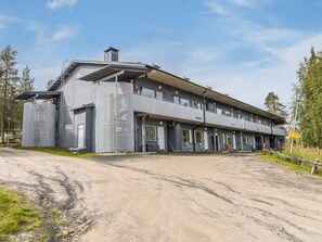 A two-story building with a flat roof, large windows, and a covered entrance area.