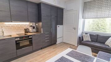 A modern kitchen with dark cabinetry, a built-in oven, and a coffee maker.