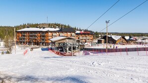 A ski resort with a lodge, ski lifts, and a snow-covered landscape.