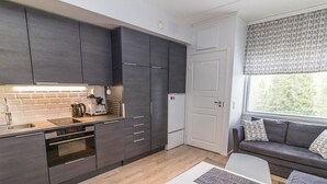 A modern kitchen with dark cabinetry, a built-in oven, and a coffee maker.
