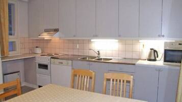 Een koelkast, een microgolfoven, kookgerei, borden en bestek