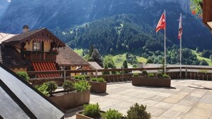 Un bâtiment de style chalet doté d’un balcon donnant sur un paysage montagneux.