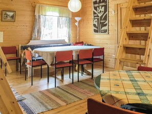 A wooden interior with a dining table, chairs, a lamp, and a ladder. - Vacation home Muisku by Interhome (Punkalaidun)