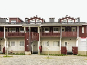 A multi-story residential building with a symmetrical facade, balconies, and a gravel driveway. - Levi star 1009 by Interhome (Kittilä)