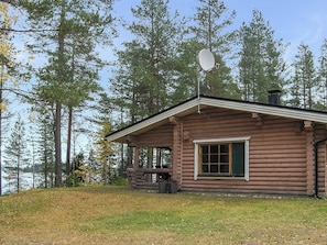 A log cabin with a porch, a chimney, and a window. - Mäntyranta by Interhome (Sotkamo)