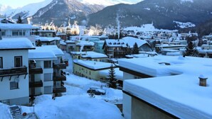 Un paese innevato con edifici e montagne sullo sfondo.