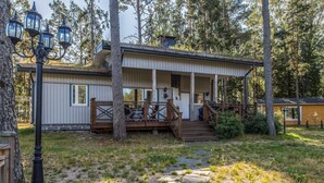 A cabin with a wooden deck, a porch, and a stone pathway leading to the entrance. - Vacation home Björn by Interhome (Kemiönsaari)