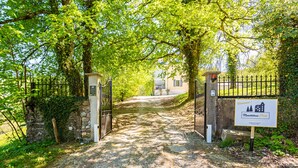 A gated entrance to a property with a sign indicating it is a Monchateau Ecole. - Monchateau étoilé Hébergement insolite (Merlas)