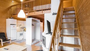 Un interior espacioso con cocina, comedor y una escalera que lleva a un nivel superior.