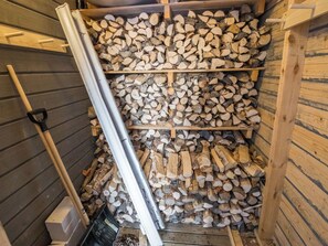 Un área de almacenamiento con estantes llenos de leña cortada.