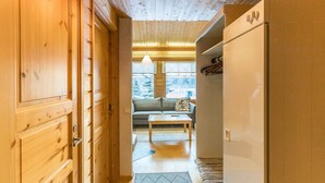 Un interior de madera con sofá, una mesa y un refrigerador.