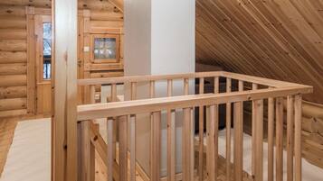 A wooden interior with a visible staircase and a white pillar.