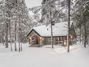 A log cabin surrounded by snow-covered trees. - Syväniemi by Interhome (Kuusamo)