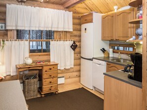 A compact kitchen with wooden cabinets, a white refrigerator, and a sink.