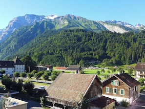 A mountain village with traditional buildings and a view of snow-capped mountains.