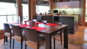 Una cucina moderna con isola centrale, mobili in legno e un'ampia finestra che permette l'ingresso di luce naturale.