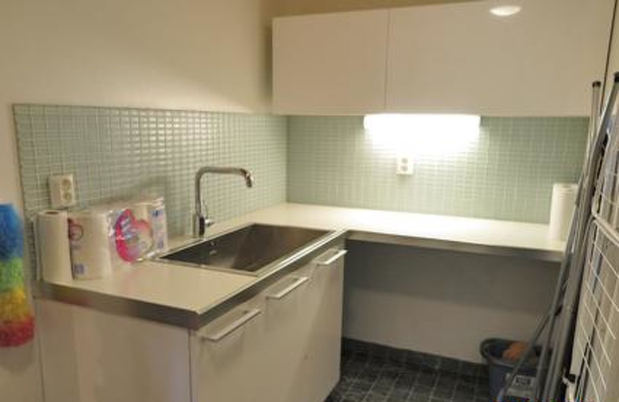 A small kitchen with a sink, a countertop, and a tiled backsplash.