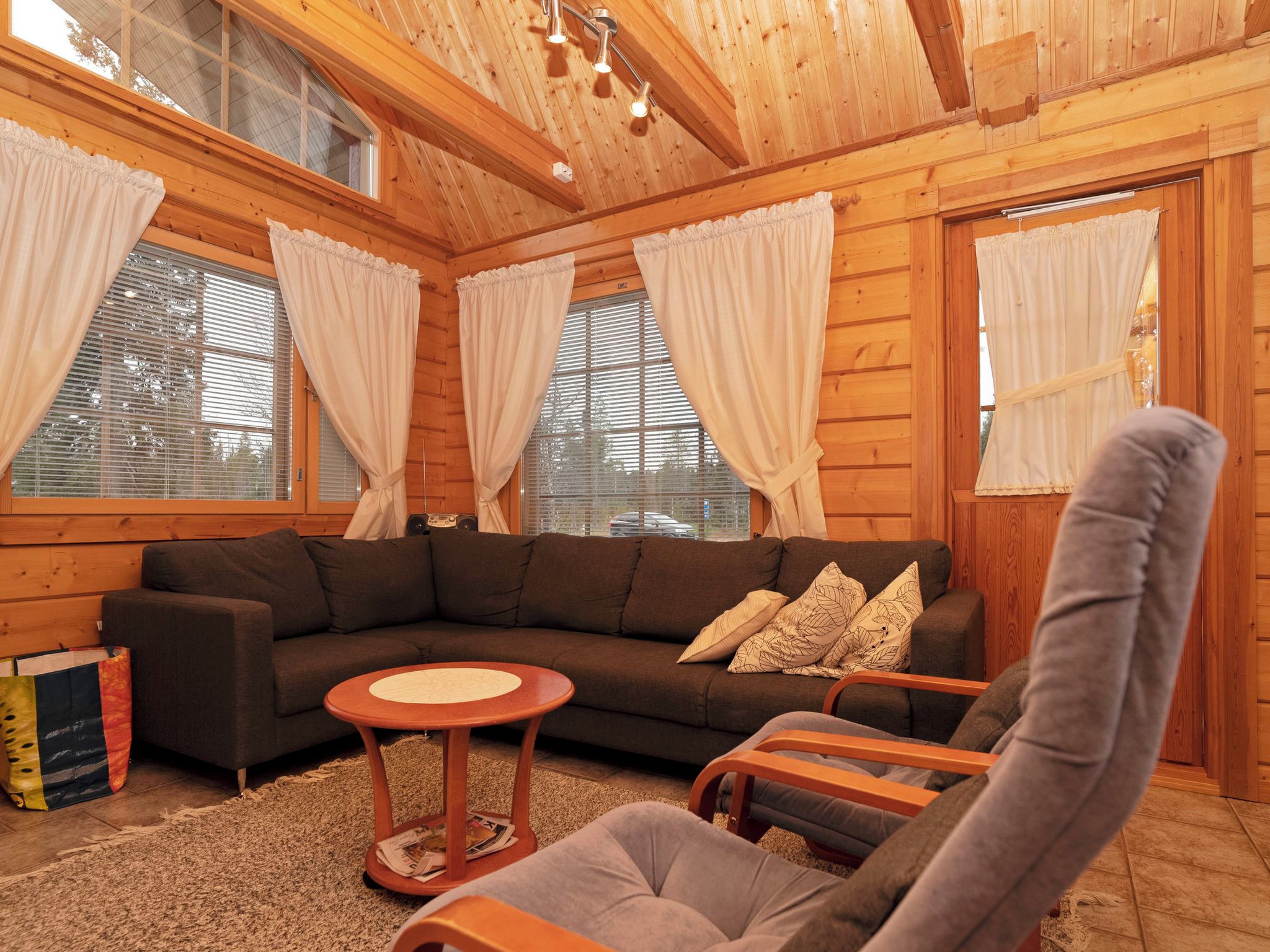 A cozy living room with a sectional sofa, a round coffee table, and two armchairs.